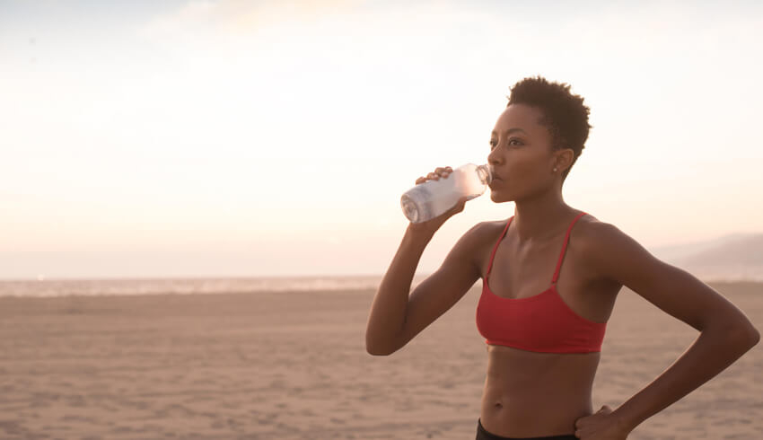 A woman drinking from a water bottle